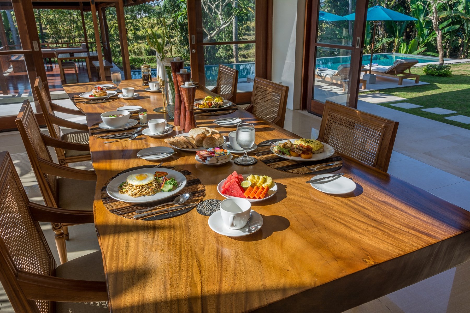 Dining table set with food and pool view